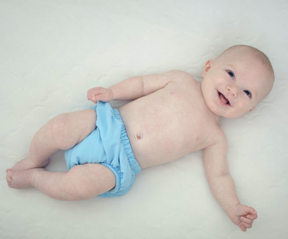 smiling baby wearing a cloth diaper