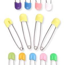 four yellow diaper pins and nine multicolour diaper pins on white background