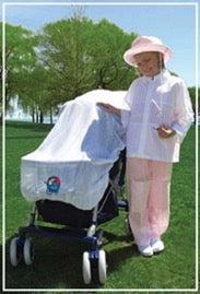 child standing in outside beside a stroller with a Sunveil sun cover over it